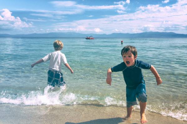 Two young boys playing on the coast of Lake Tahoe.